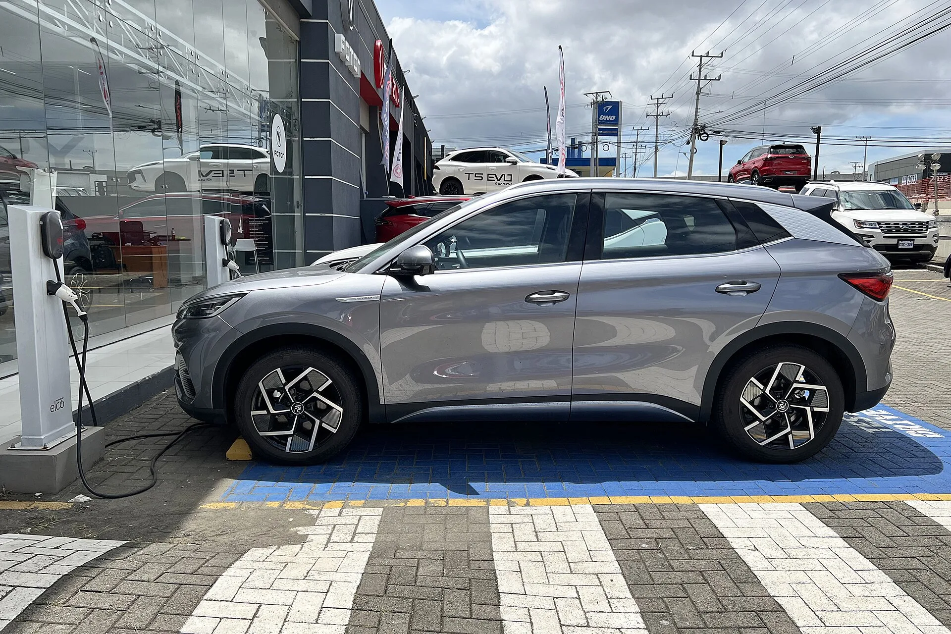 Carro elétrico circulando em avenida de São Paulo, ilustrando a isenção do rodízio municipal para elétricos e híbridos